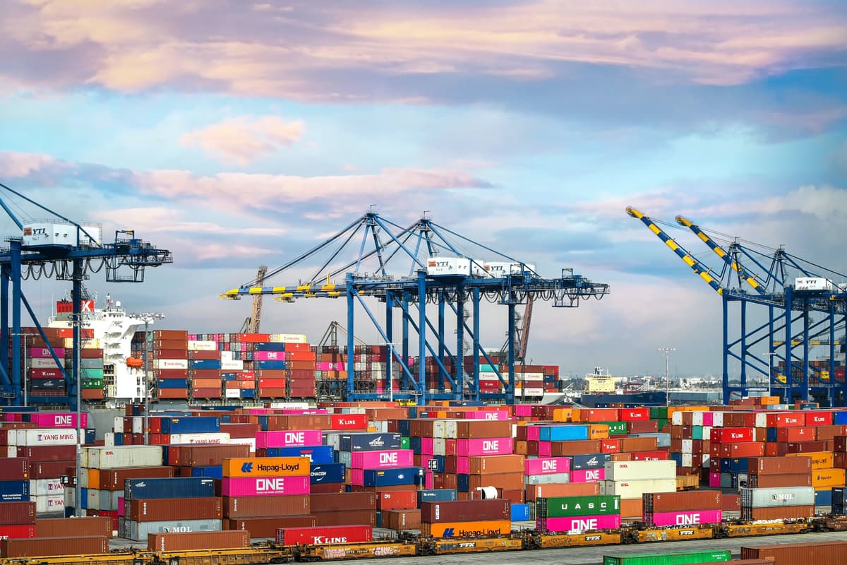 Aerial view of trucks and cargo containers with AI-powered logistics technology overlay